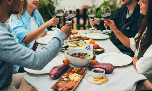 a group of people having a meal around an outdoor table